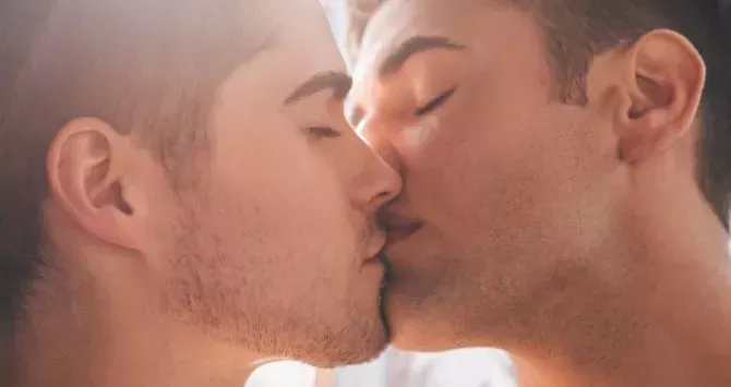 Two men share a kiss