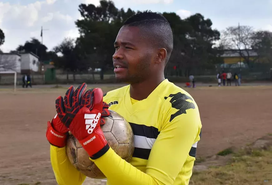 Out gay South African footballer Phuti Lekoloane holding a football