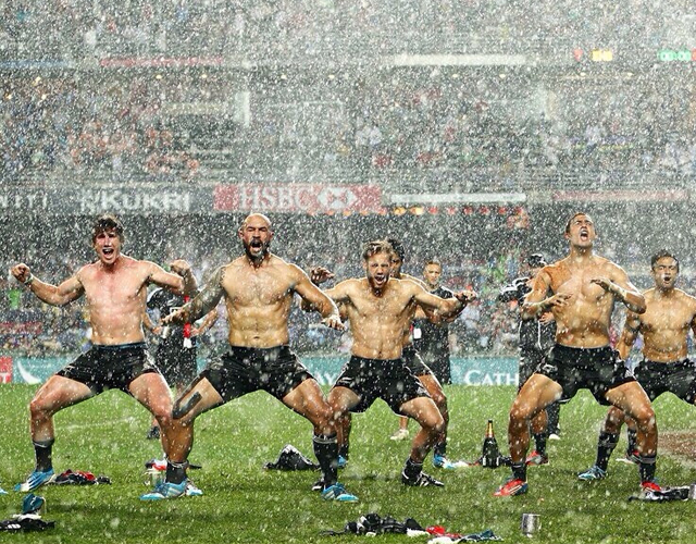 Jugadores de rugby sin camiseta bailando bajo la lluvia