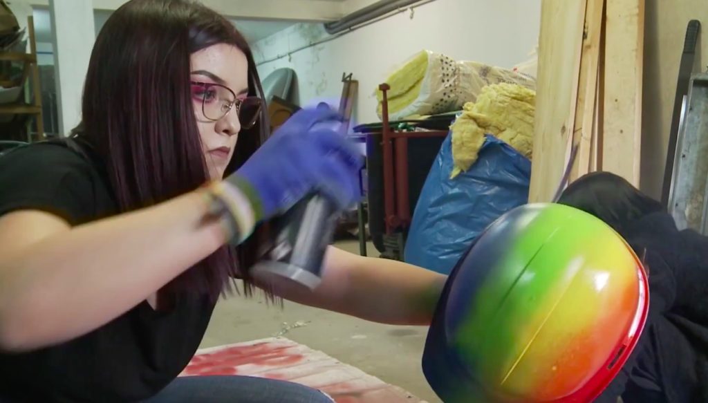 Activista LGBT pinta cascos con colores del arco iris
