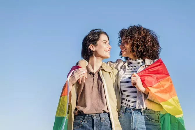 Lesbian couple wrapped in rainbow Pride Flag