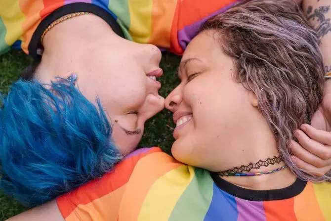 Lesbian teen couple wearing rainbow shirts