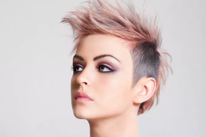 Head shot of a serious looking young woman sporting a pink punk haircut