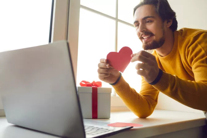 Man holding heart to webcam