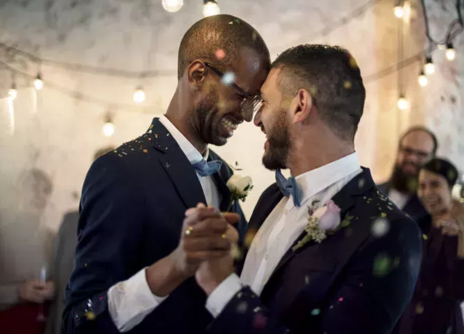 Close up of newlywed gay couple dancing at wedding party