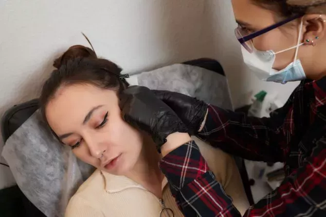 Professional holding the jewel of piercing just before screwing the ball