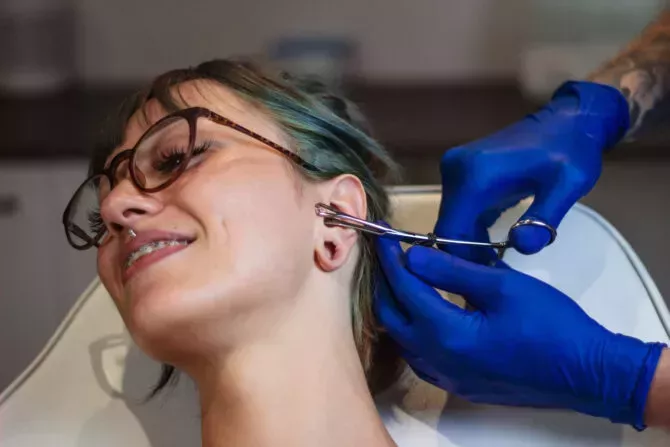 woman getting her ear pierced