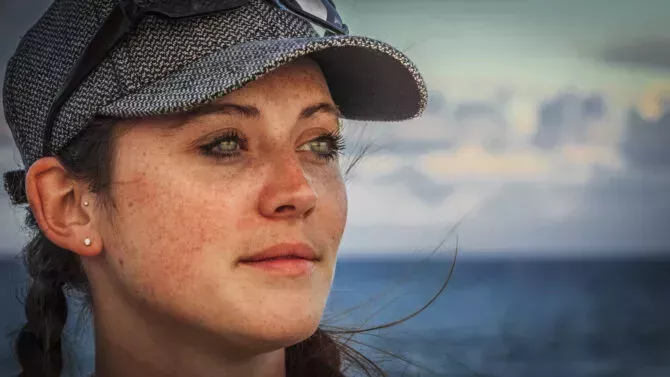 Portrait of a young woman, Caribbean Sea in the background.