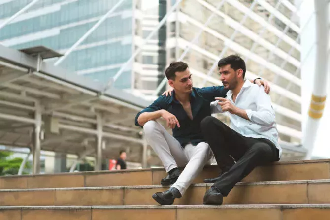Two men sitting on stairs outdoors