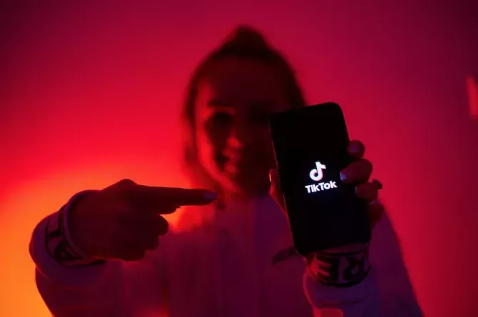 Girl pointing to TikTok on her phone