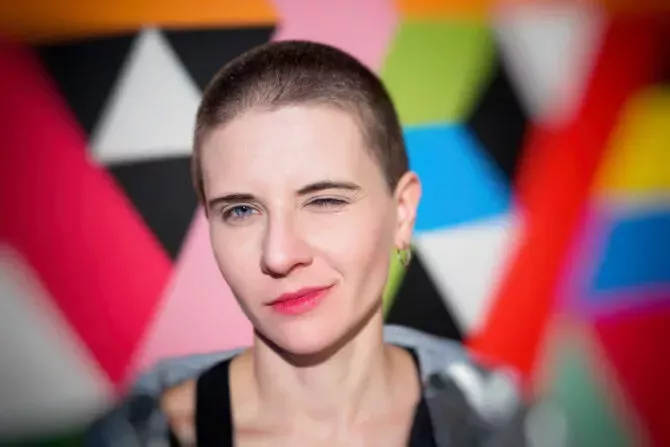 Close-up portrait of young emotional woman with short hair on bright geometric background