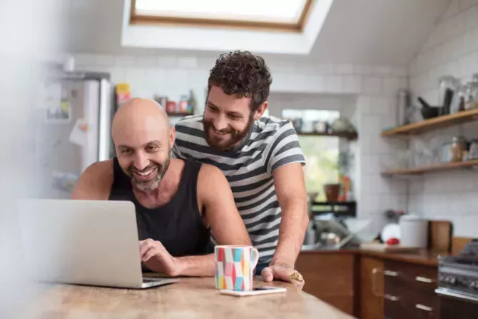 Gay couples use laptop in the kitchen
