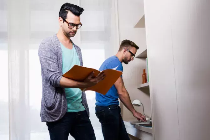 Happy gay couple working together in office