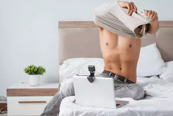 Man taking off shirt on webcam