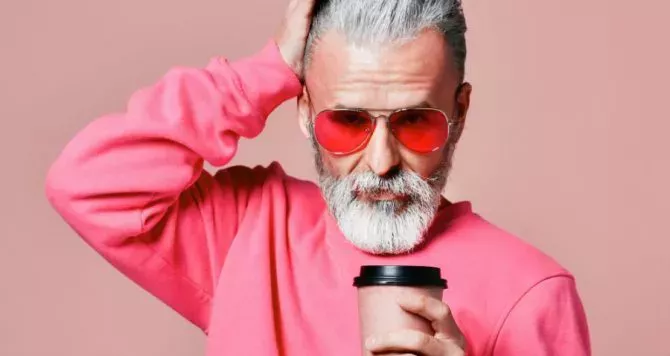 A hip older man wearing pink sunglasses