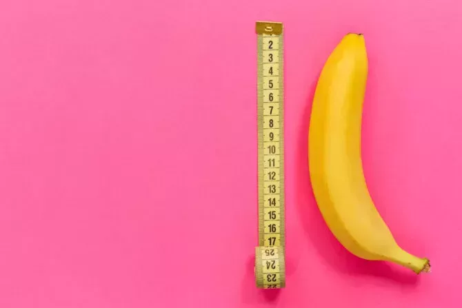 Yellow banana with measuring tape on pink background