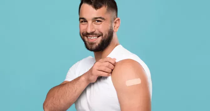 A man displays a vaccine plaster on his arm