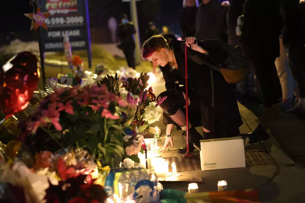 People hold a vigil at a makeshift memorial near the Club Q nightclub in Colorado Springs, Colorado.