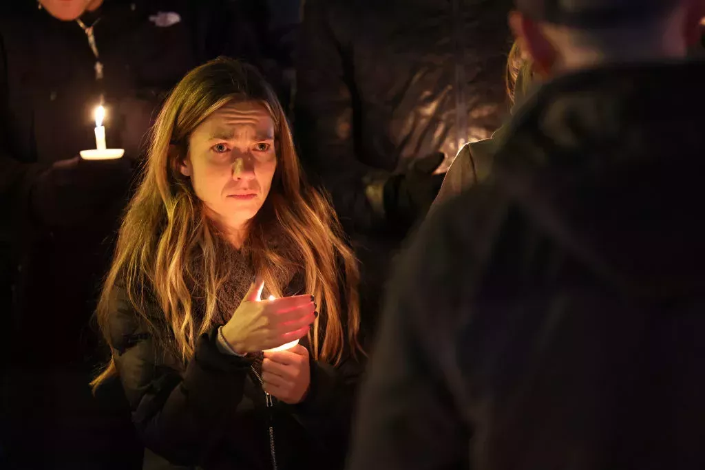 People hold a vigil at a makeshift memorial near the Club Q nightclub in Colorado Springs, Colorado.