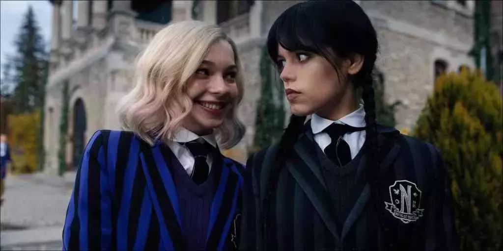 A still from new Netflix series Wednesday shows actors Emma Myers and Jenna Ortega as characters as Enid Sinclair and Wednesday Addams dressed in their school uniform costumes Enid Sinclair (L) and Wednesday (R). (Netflix)
