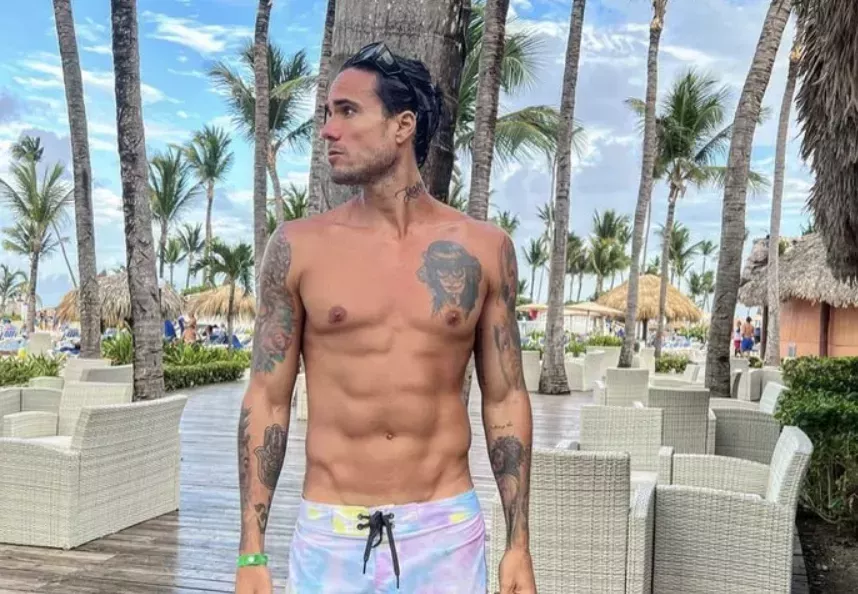 Gino Assereto posing shirtless on the beach