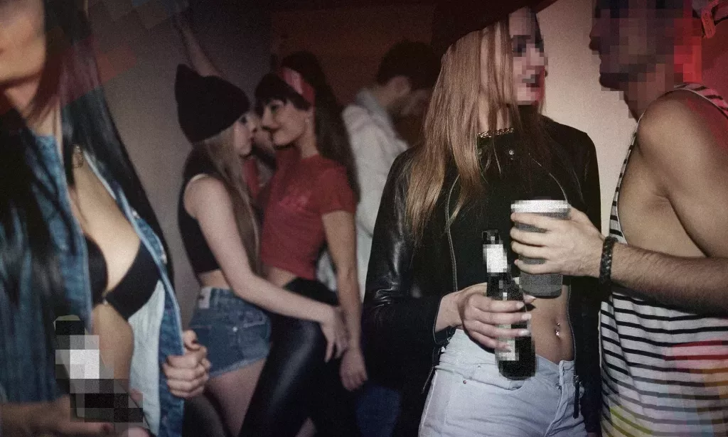 People dancing and drinking at a house party.