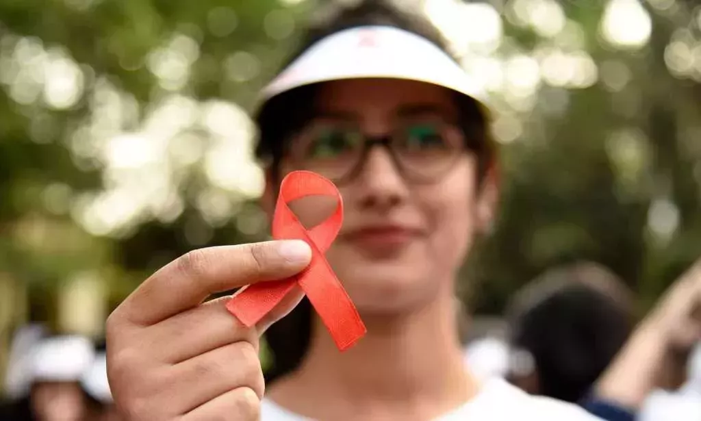 Student with a red HIV awareness ribbon