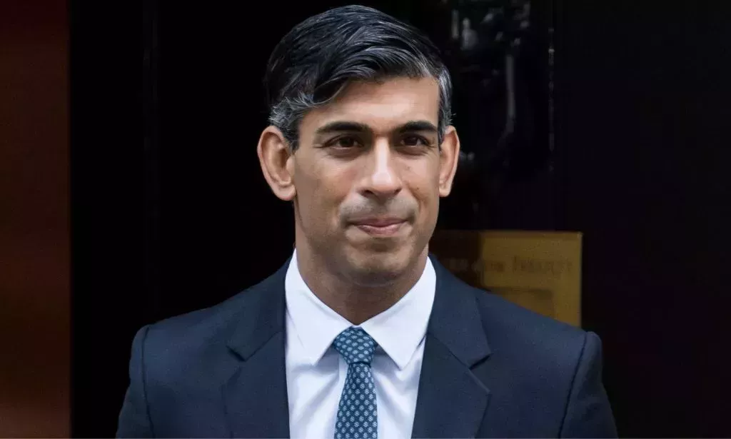 Rishi Sunak leaving Number 10, smiling.