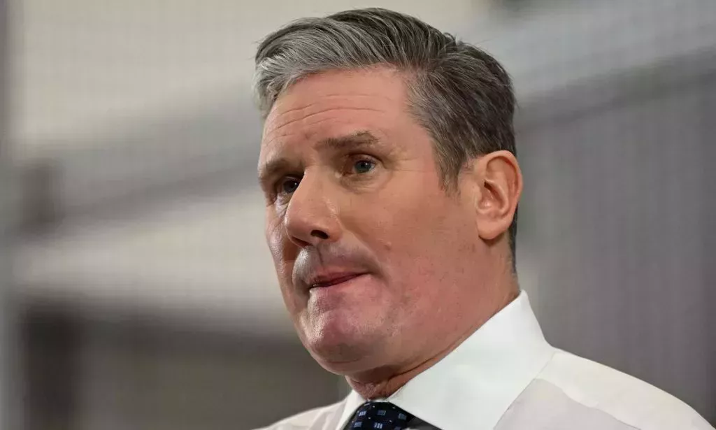 Keir Starmer in a suit and tie, looking off into the distance.