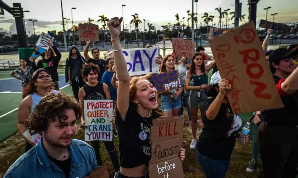 People hold up signs in support of the LGBTQ+ community as they protest against Florida governor Ron DeSantis, who championed the state's 'Don't Say Gay' bill