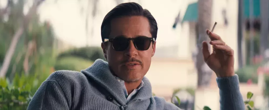 Brad Pitt plays Jack Conrad in Babylon smoking in a grey jumper. (Paramount Pictures)