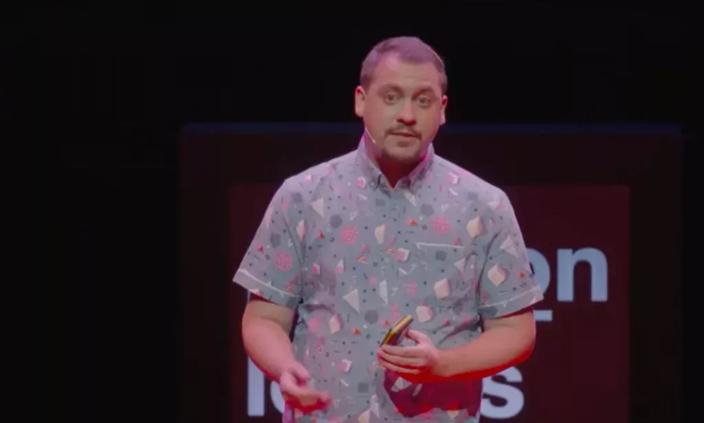 Leng Montgomery wears a patterned shirt as he gives a TEDx Talk on trans inclusion in the workplace