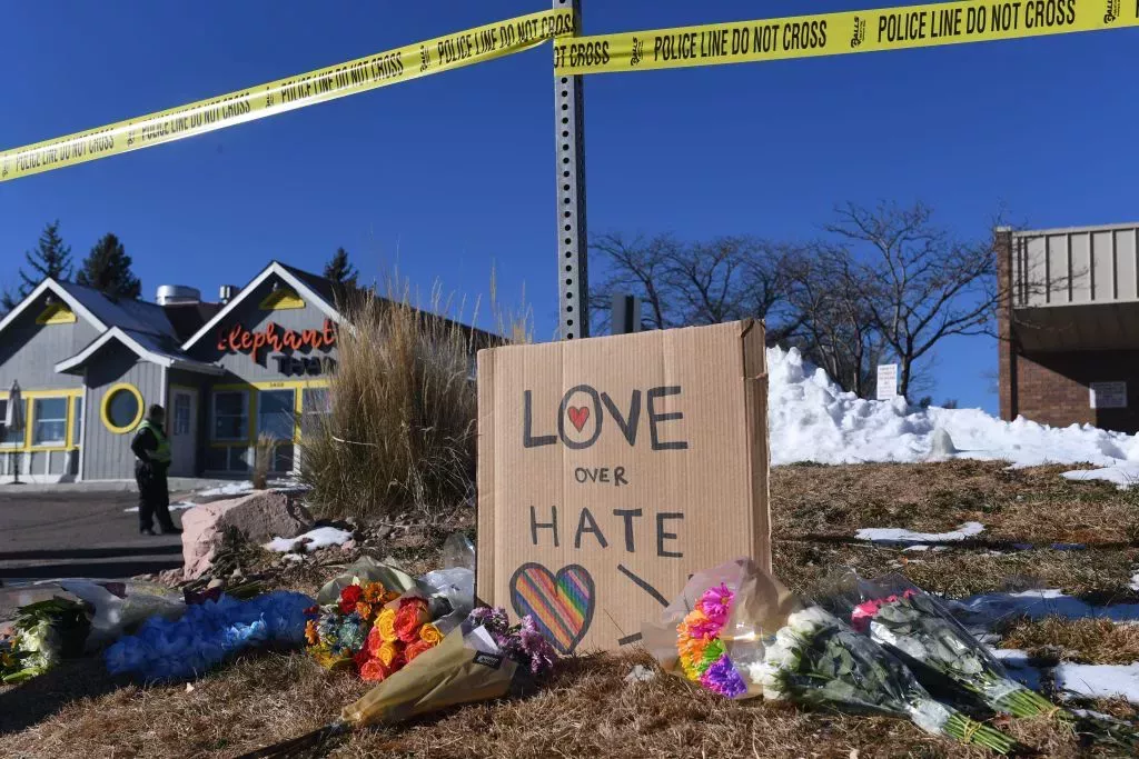 Bouquets of flowers and a sign reading "Love Over Hate" are left near Club Q, an LGBTQ nightclub in Colorado Springs, Colorado, on November 20, 2022.