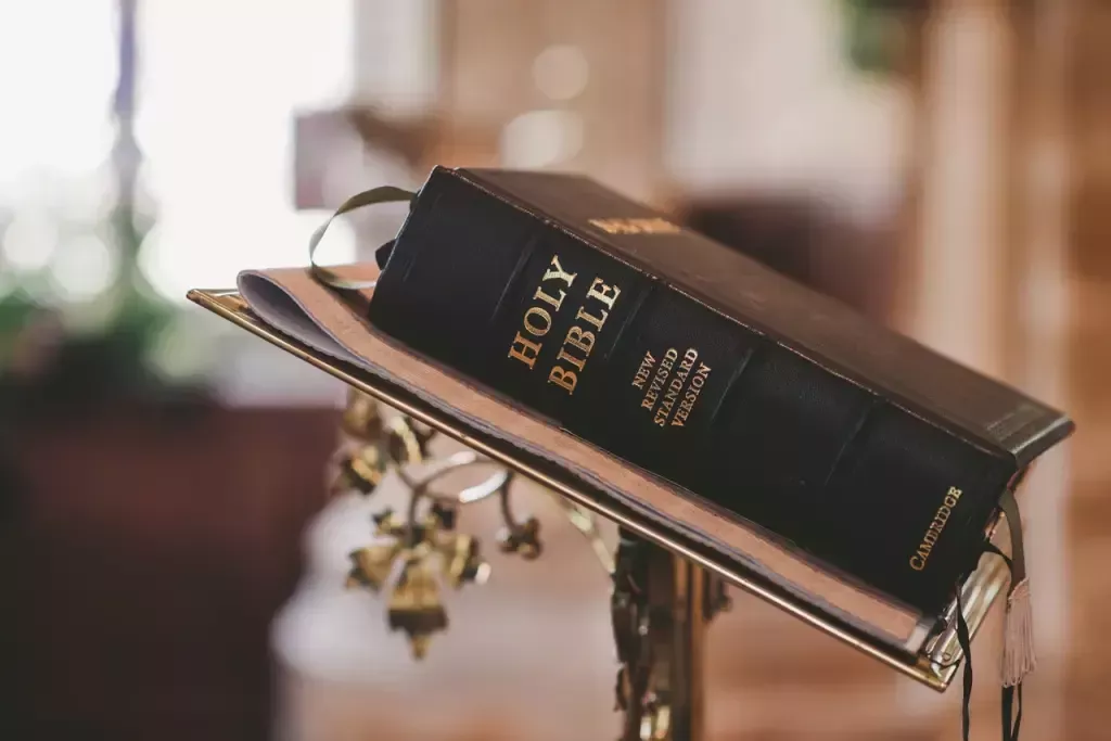 A black Bible with gold foil writing that reads 'Holy Bible' on a lectern