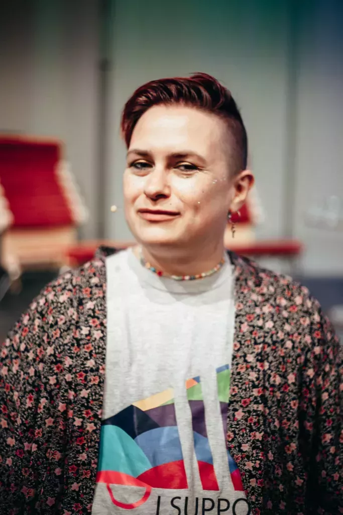 Edward Reese of Kyiv Pride. He is pictured with short hair and earrings and is wearing a cardigan and a t-shirt.