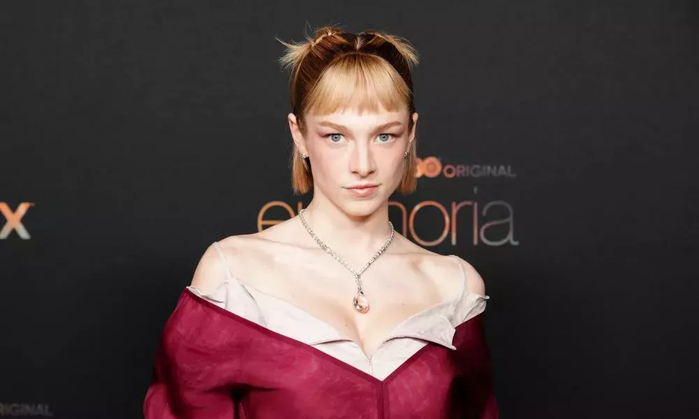 Hunter Schafer, a star of the HBO show Euphoria, looks at the camera while wearing a red dress