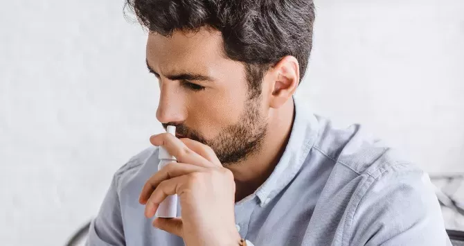 A man uses a nasal spray