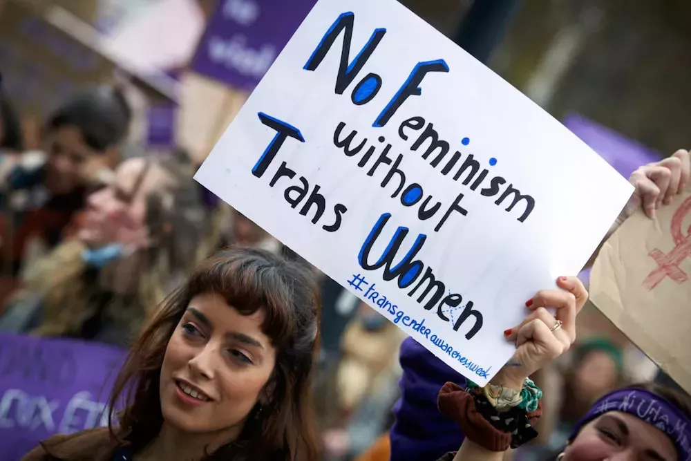 A protester holds a sign that reads: 'No feminism without trans women'