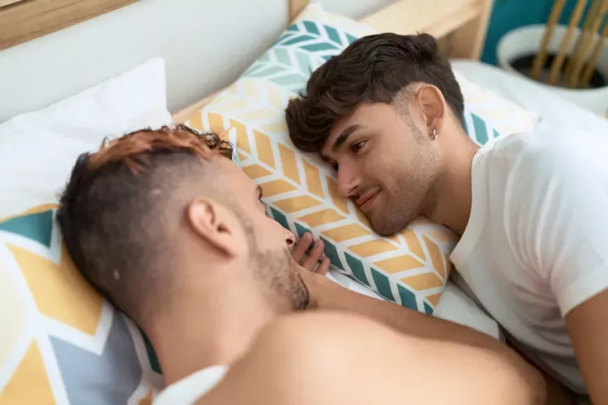 Two men cuddling in bed