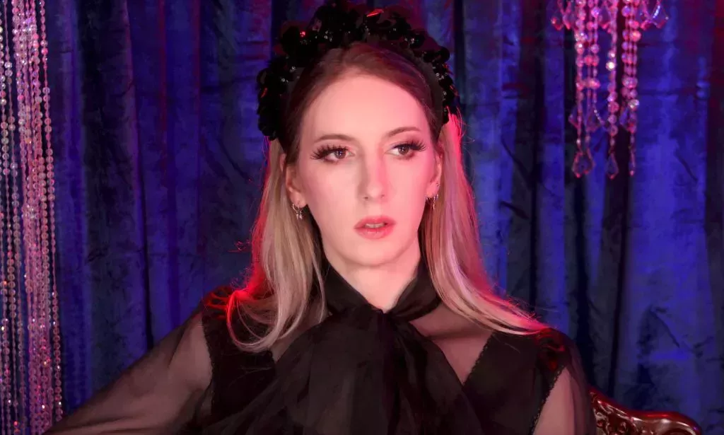 An image of ContraPoints on-set with a blue background.