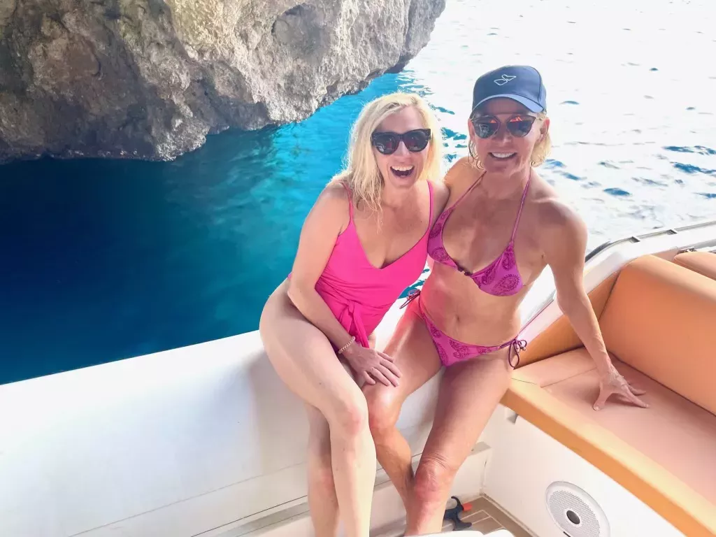 Liz Hilliard (R) with Lee (L). They are pictured here wearing pink swimsuits on a boat.