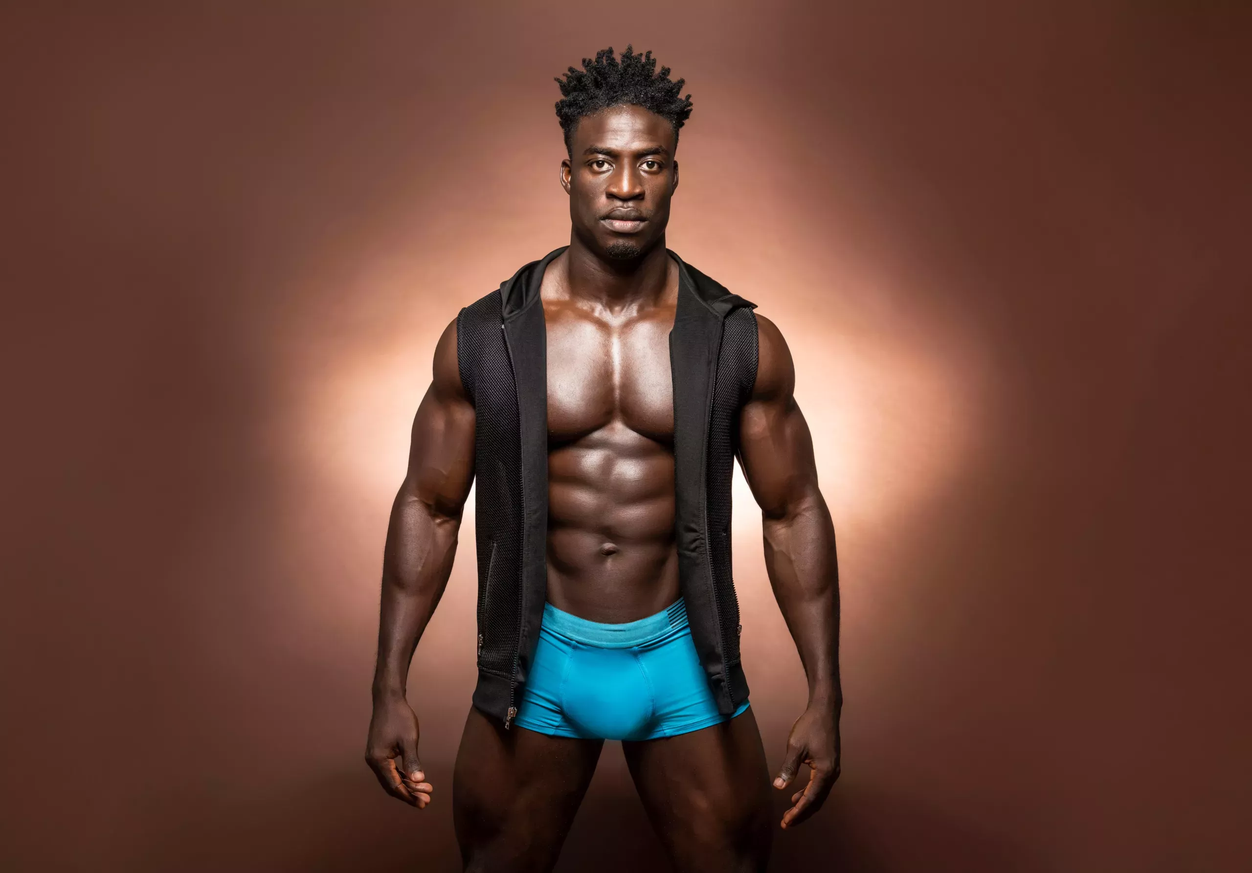 Boyboybuilder with open vest and neon blue boxers showing bulge.