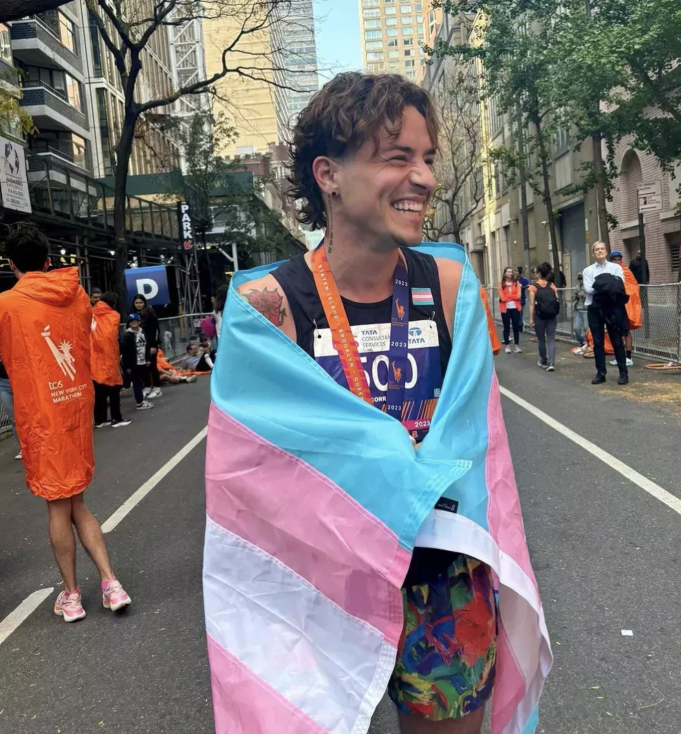 Runner Cal Calamia wrapped in the Transgender Pride Flag after finishing the New York City Marathon.