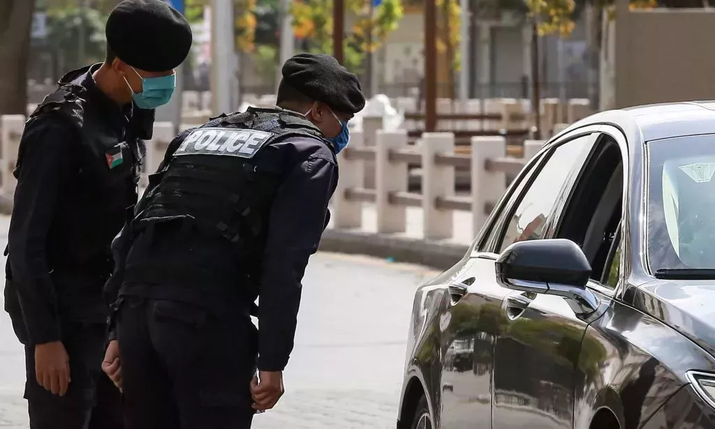 Police approach a car in Jordan.