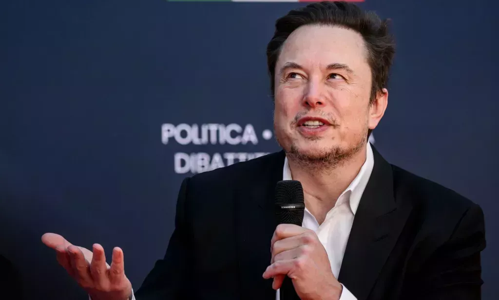 Elon Musk wears a white shirt and black jacket as he speaks about why people should have more babies at a right-wing event in Italy