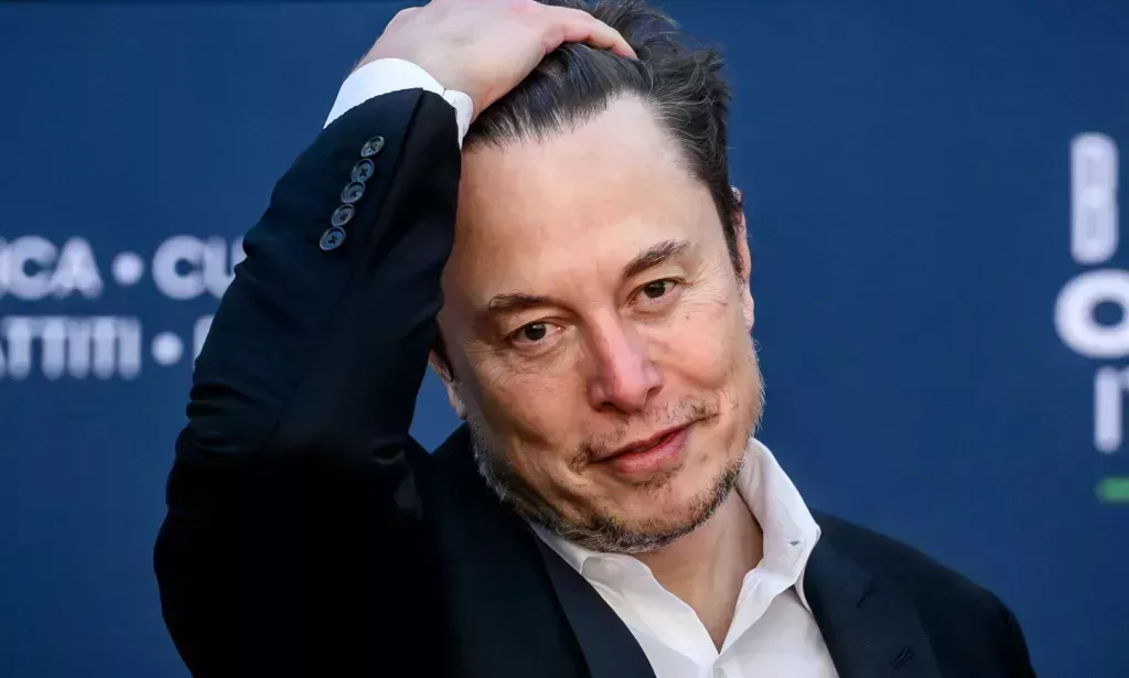 Elon Musk slicking his hair back.