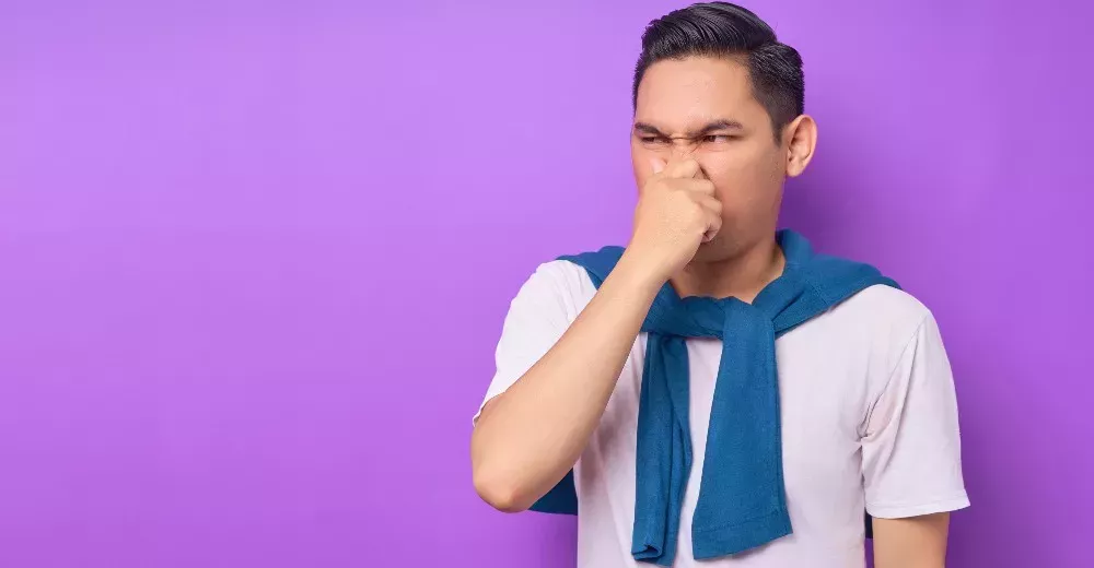 A man is disgusted by a bad smell