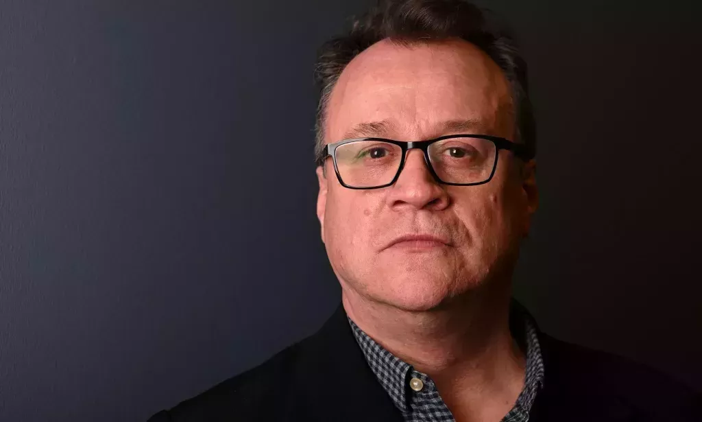 A headshot of Russell T Davies infront of a grey background.