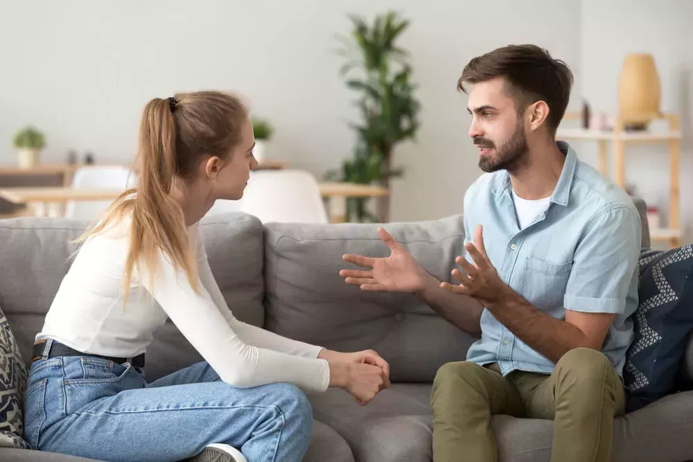 Man and woman having a serious conversation on a sofa