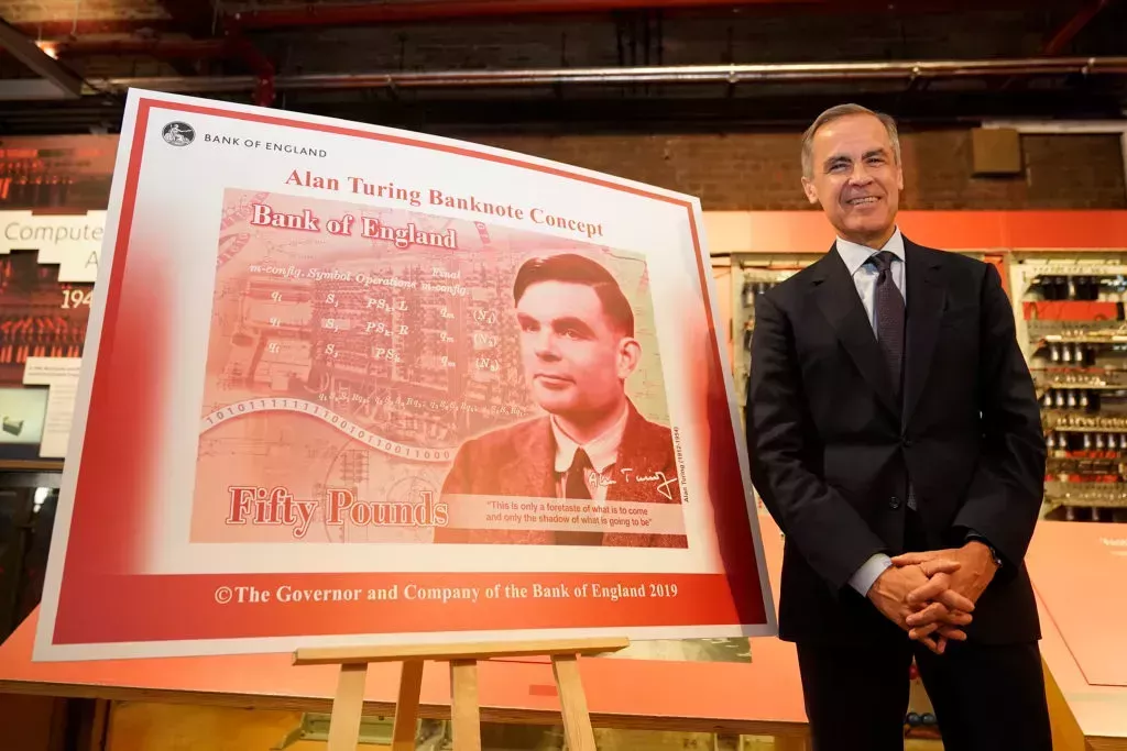 Mark Carney in front of a large illustration of the Alan Turing note